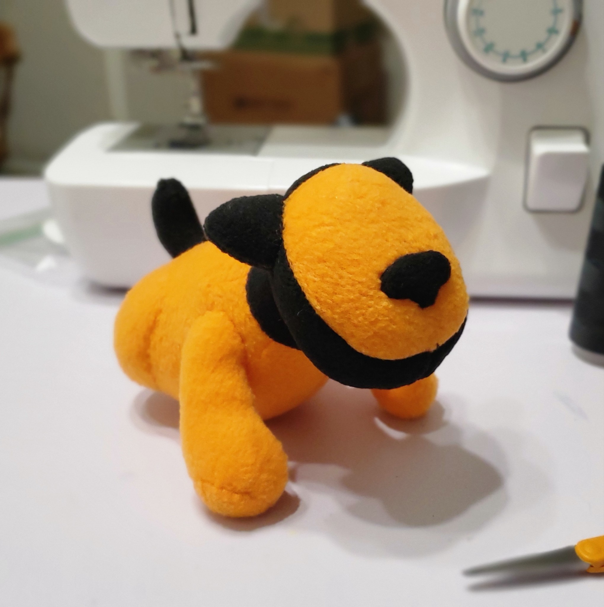 A photograph of a plush made by DayLikesCookies. The design is of a retro robot dog.