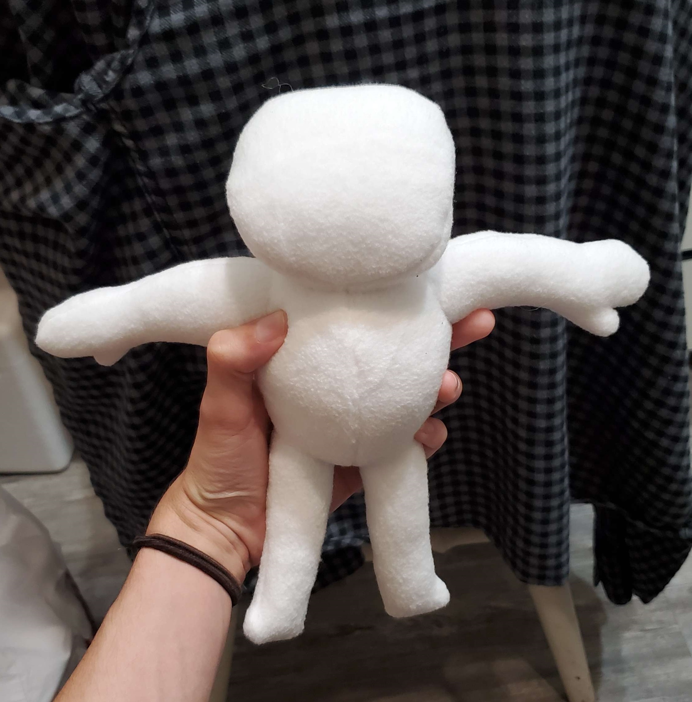 A photograph of a plush made by DayLikesCookies. The design is inspired by a character called The Spot.