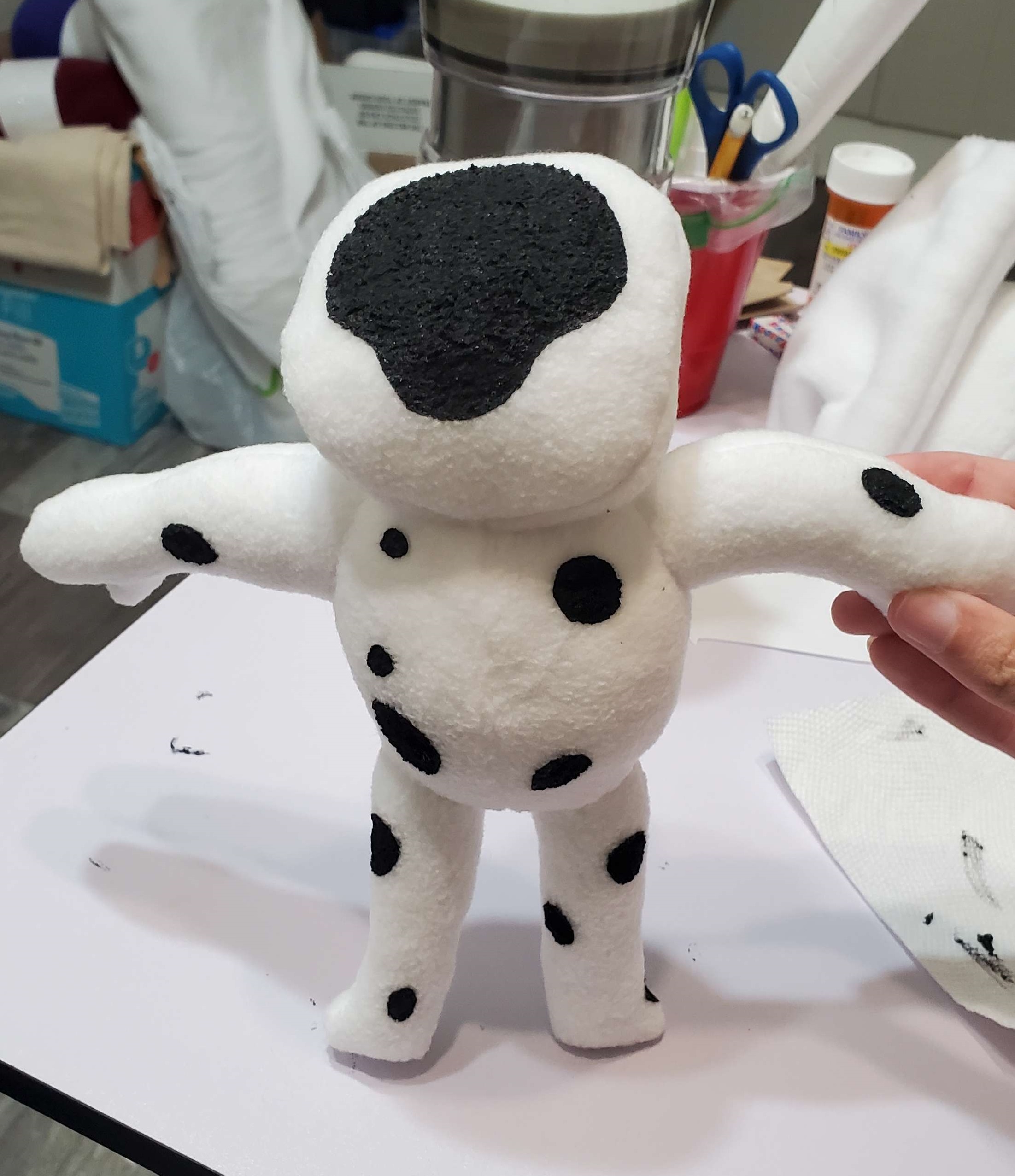 A photograph of a plush made by DayLikesCookies. The design is inspired by a character called The Spot.